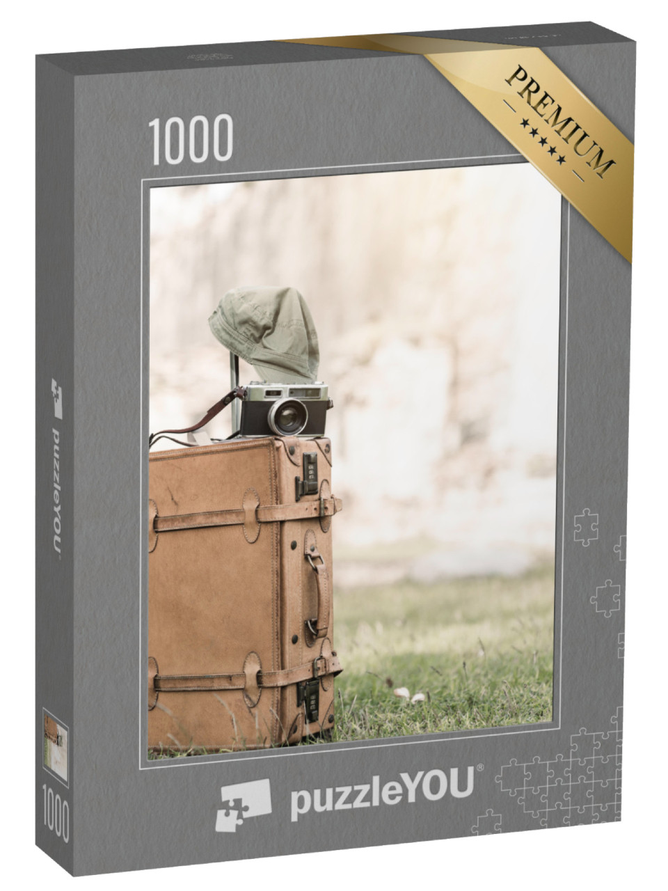 puzzle 1000 dílků „Vintage fotoaparát na starém brašně v trávě“