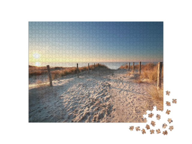 puzzle 1000 dílků „Sluneční světlo nad písečnou cestou na pláž Severního moře, Holandsko“