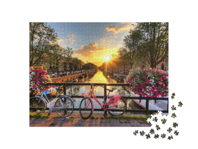 puzzle 1000 dílků „Krásný východ slunce nad Amsterdamem s květinami a koly na mostě“