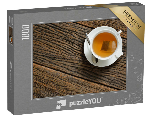 puzzle 1000 dílků „Pohled shora na šálek čaje s čajovým sáčkem na dřevěném stole...“